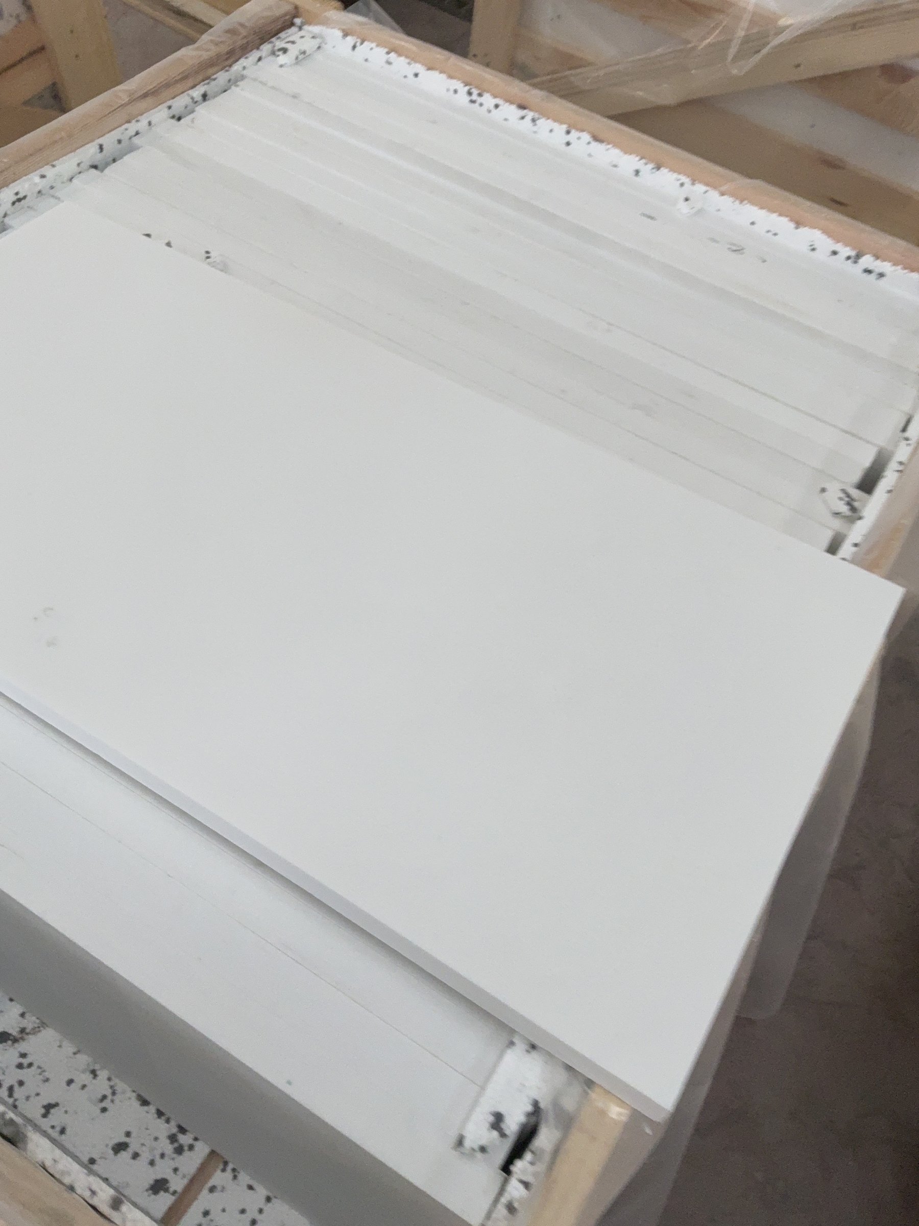 Opened wooden crate containing upright marble slabs separated by timber spacers
