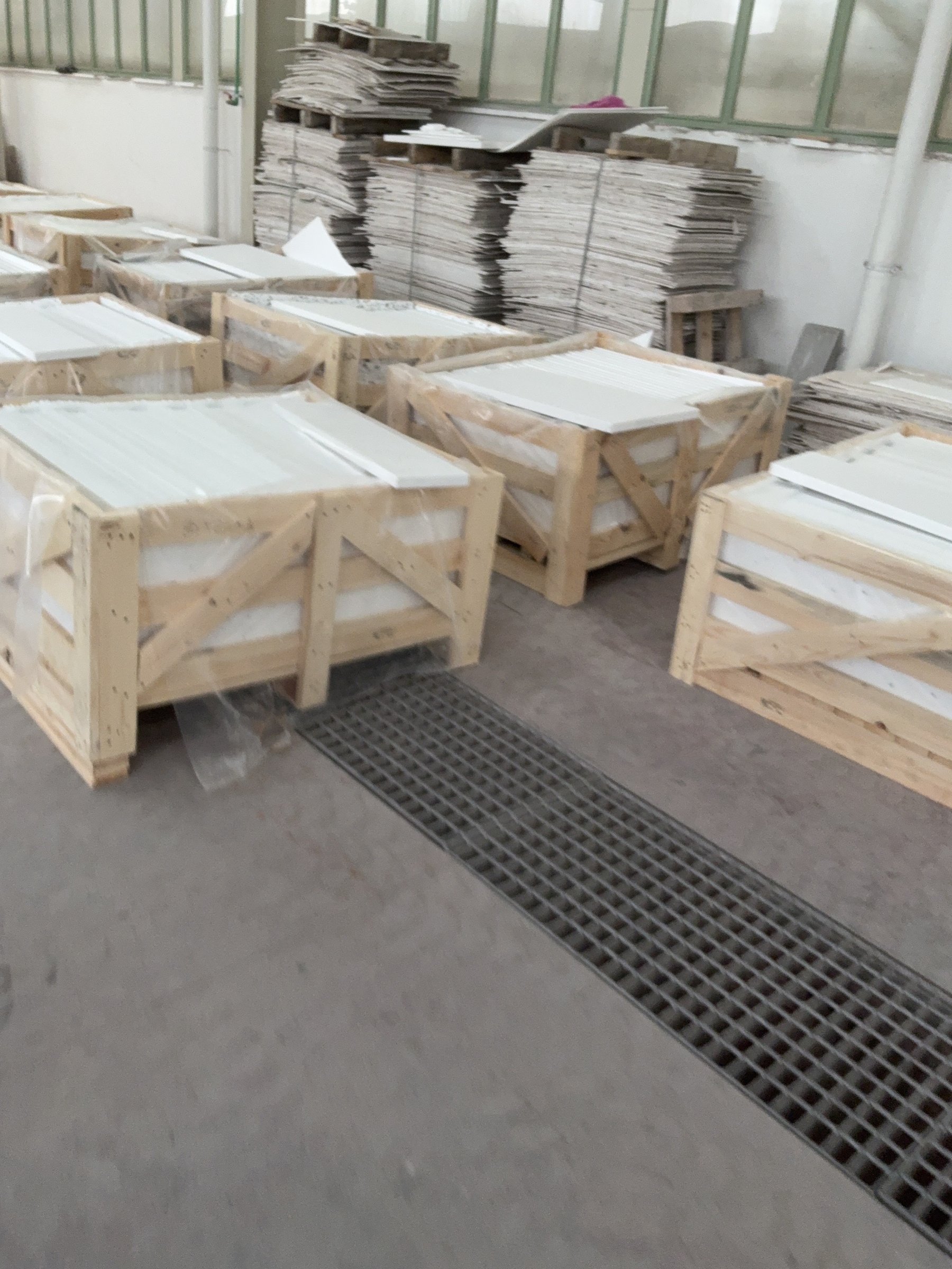 Rows of wooden export crates holding white marble slabs