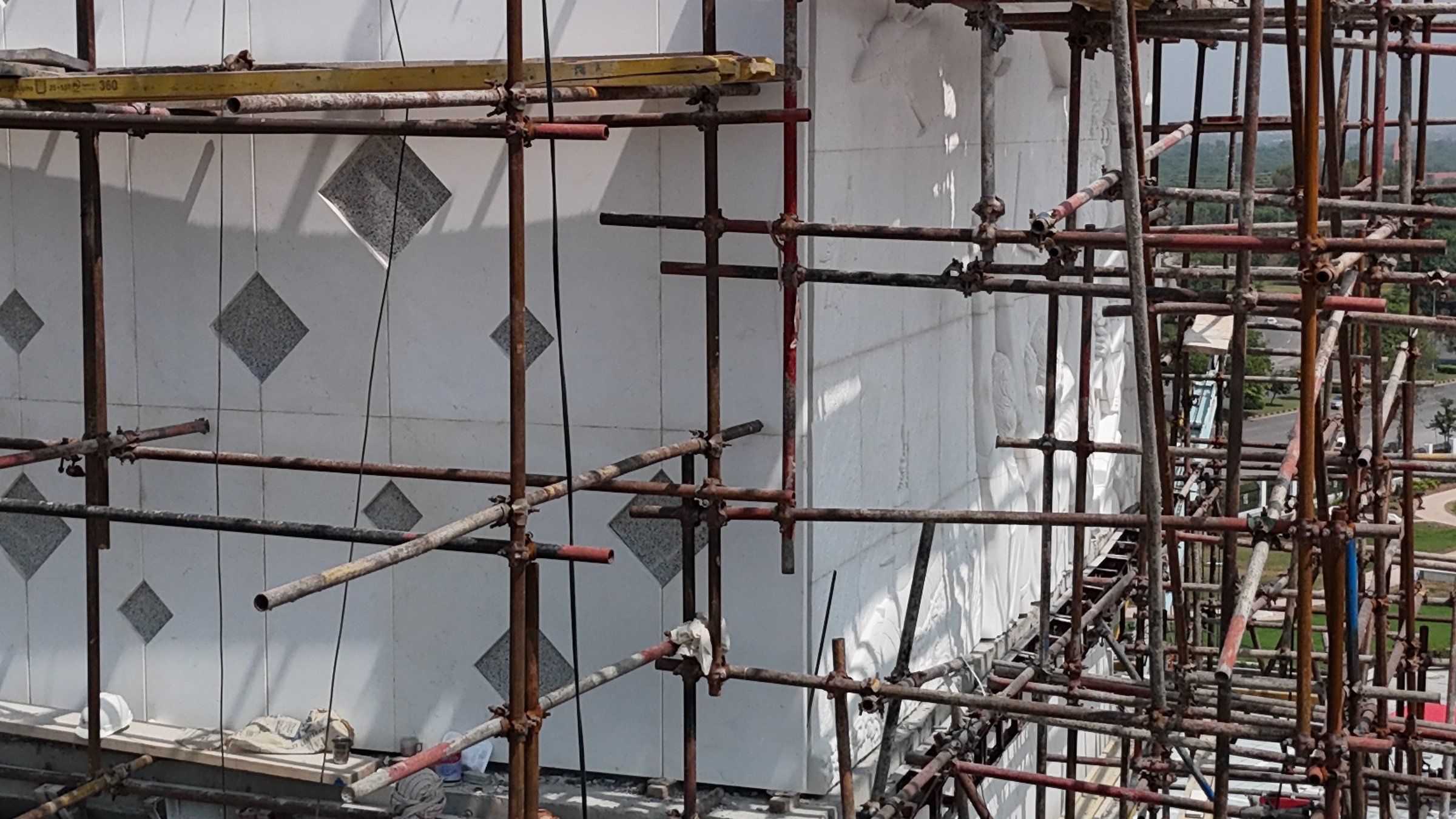 White marble facade with diamond inlay panels taking shape behind scaffolding
