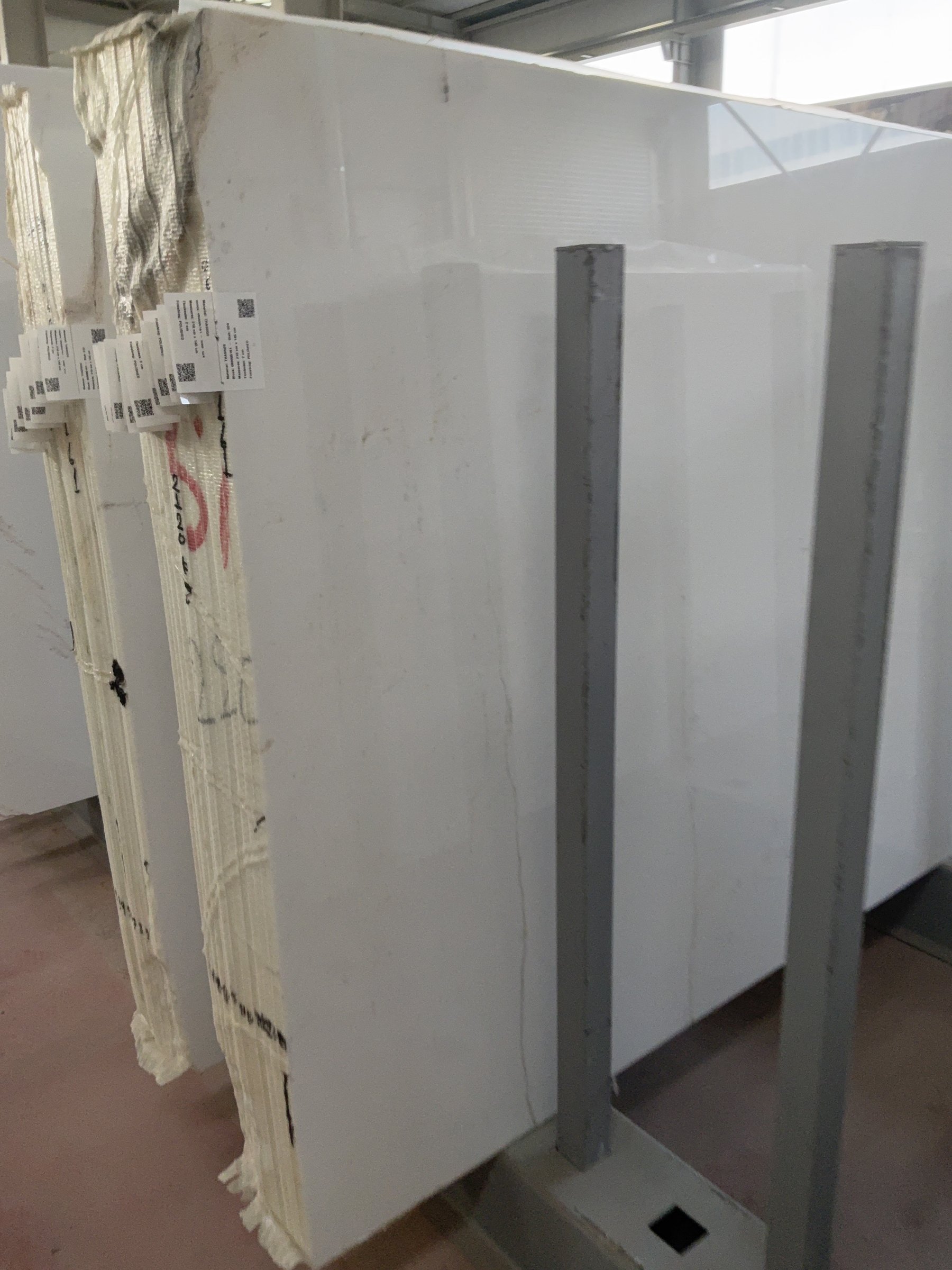 Close view of printed labels attached to the edges of stacked marble slabs