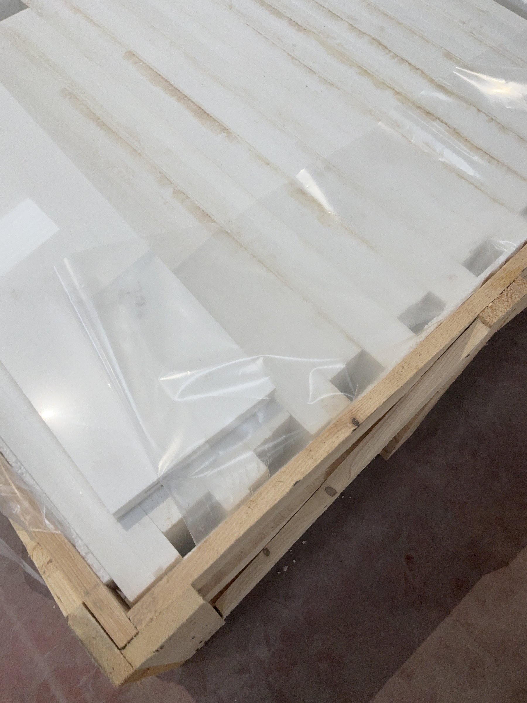 Thassos White marble slabs wrapped in protective film inside a wooden crate